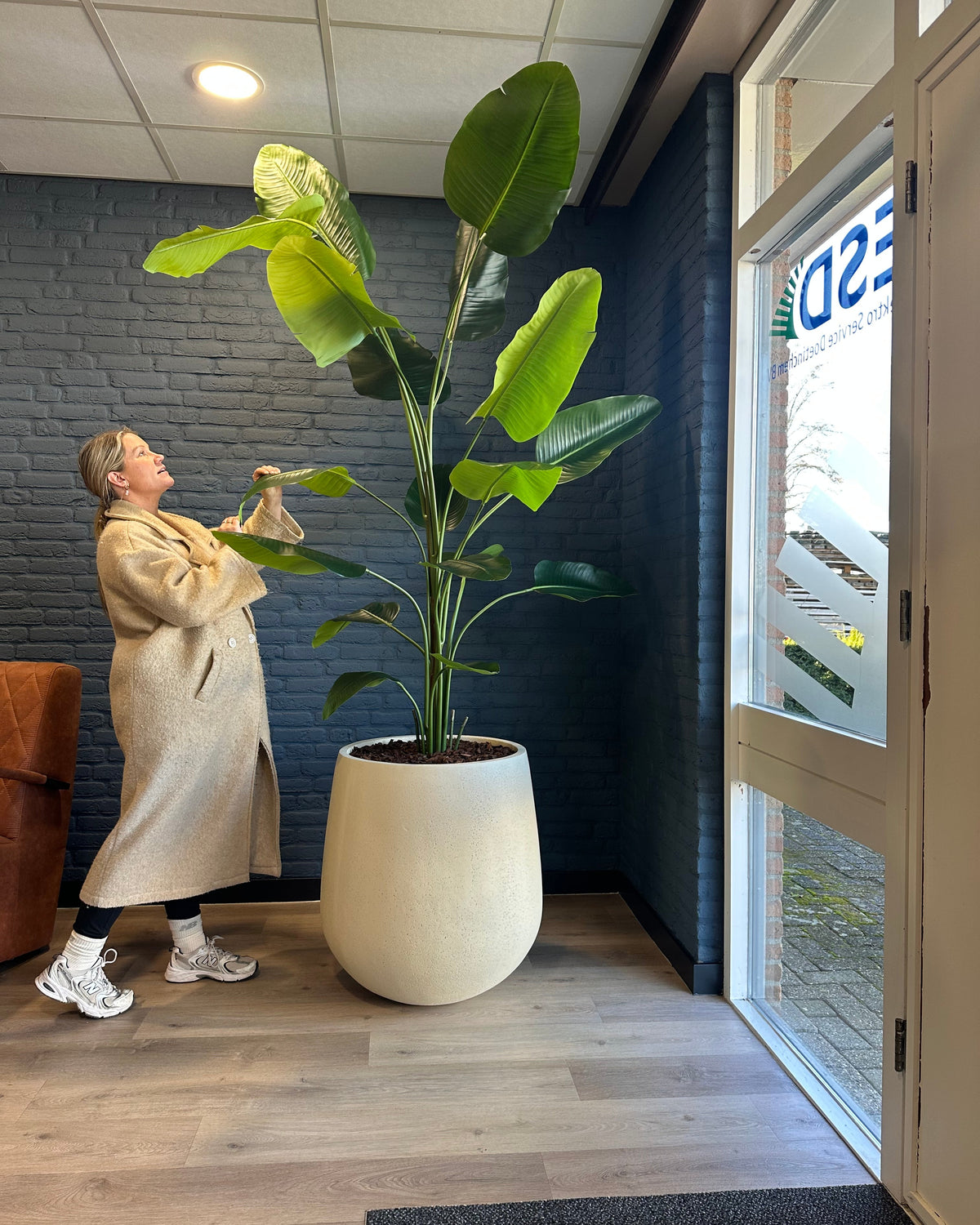 Strelitzia kunstplant in grote beige pot van Bloom of Life, realistische kunstplant voor interieurbeplanting in kantoor of winkel.